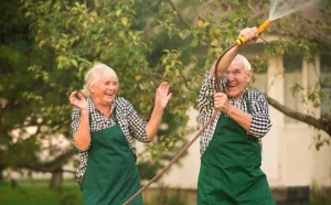 Elderly Couple Playing Garden Hose 768x475